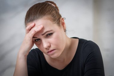 Üzgün, hayal kırıklığına uğramış genç, çaresiz bir kadının portresi. Elini tutarak zor bir hayat, sorunlar ya da baş ağrısı çekiyor. Umutsuzluk, depresyon, yalnızlık konsepti.