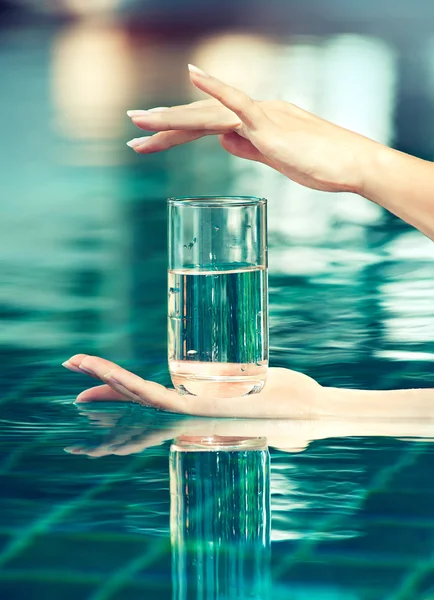 Женские руки со стаканом воды — стоковое фото
