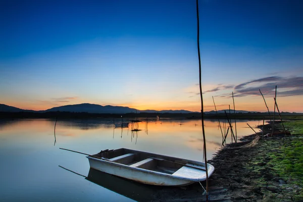 Barco de pesca en el lago con hermoso fondo de luz del amanecer . —  Fotos de Stock