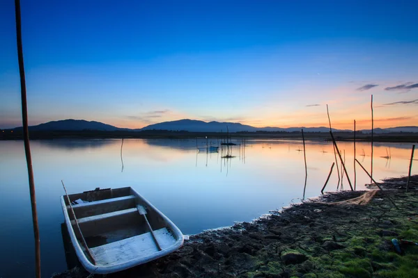 Fiskebåt i sjön med vacker gryning ljus bakgrund. — Stockfoto