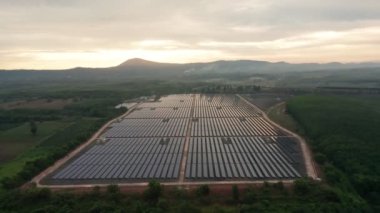 Hava aracı görüntüsünün ikinci görüntüsü bir güneş çiftliğindeki büyük güneş panellerine doğru bakıyor. Güneş pili santralleri. Yeşil Enerji güneş enerjisi. görüntüler 4k.