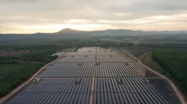 Hava aracı görüntüsünün ikinci görüntüsü bir güneş çiftliğindeki büyük güneş panellerine doğru bakıyor. Güneş pili santralleri. Yeşil Enerji güneş enerjisi. görüntüler 4k.