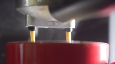 Kahve makinesinin fincanından dökülen kahvenin görüntüsü. Ev yapımı sıcak Espresso. Filtre tutacağı kullanılıyor. Taze kahve akıyor. Sabahları kavrulmuş sade kahve içmek.. 