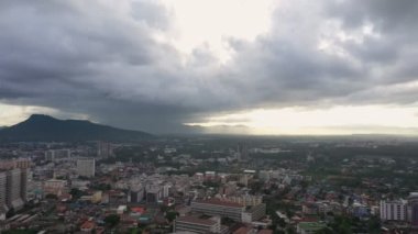 Airial View Drone 'un B görüntüsü. Şehir manzarasının yavaş çekim sahnesini hareket ettiriyor. Dağda güneş doğuyor. Gündoğumunda gökyüzü ve bulutlar. Şehir merkezinin B-film sahnesi.