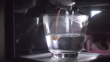 Kahve makinesinin fincanından dökülen kahvenin görüntüsü. Ev yapımı sıcak Espresso. Filtre tutacağı kullanılıyor. Taze kahve akıyor. Sabahları kavrulmuş sade kahve içmek.. 