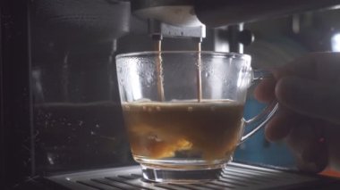 Kahve makinesinin fincanından dökülen kahvenin görüntüsü. Ev yapımı sıcak Espresso. Filtre tutacağı kullanılıyor. Taze kahve akıyor. Sabahları kavrulmuş sade kahve içmek.. 