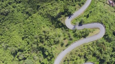 Airial Viraj Drone 'un ikinci kaydı peyzaj yılanlı virajlı yolda uçuyor. Virajlı yolda giden bir araba. İHA 4K Video. Yaz güneşli bir günde dağlarda dolan yollar..