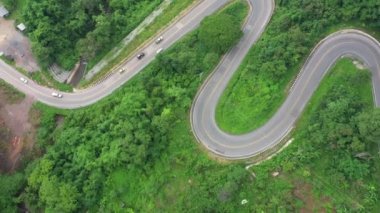 Airial Viraj Drone 'un ikinci kaydı peyzaj yılanlı virajlı yolda uçuyor. Virajlı yolda giden bir araba. İHA 4K Video. Yaz güneşli bir günde dağlarda dolan yollar..