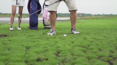 Çift aşığının birlikte golf oynadığı görüntüler. Golf topunu sahadan sahaya atarken aile sahasında zor zamanlar geçiriyoruz. Golf provası doğa alanlarında.