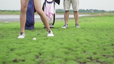 Çift aşığının birlikte golf oynadığı görüntüler. Golf topunu sahadan sahaya atarken aile sahasında zor zamanlar geçiriyoruz. Golf provası doğa alanlarında.