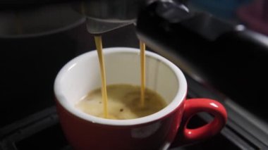 Kahve makinesinin fincanından dökülen kahvenin görüntüsü. Ev yapımı sıcak Espresso. Filtre tutacağı kullanılıyor. Taze kahve akıyor. Sabahları kavrulmuş sade kahve içmek.. 