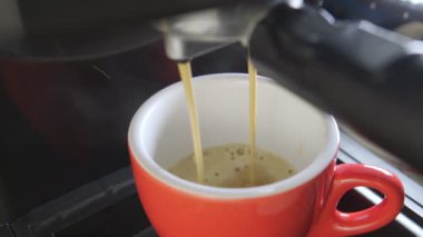 Kahve makinesinin fincanından dökülen kahvenin görüntüsü. Ev yapımı sıcak Espresso. Filtre tutacağı kullanılıyor. Taze kahve akıyor. Sabahları kavrulmuş sade kahve içmek.. 