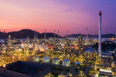 Petrol rafineri fabrikası endüstrisi ile petrol depolama tankının hava görüntüsü. Güneş batımında ve alacakaranlıkta petrol rafinerisi. sanayi fabrikası kavramı ve taşımacılığı.