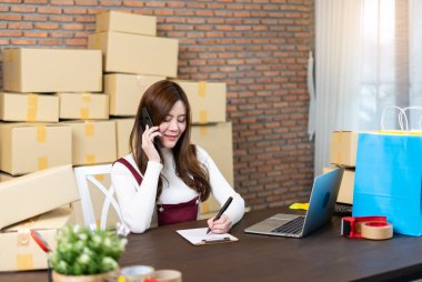 Küçük işletme girişimcisi KME ya da evde ya da ofiste kutularla çalışan serbest çalışan kadın. Teslimat paketleriyle ilgileniyordum. Çevrimiçi pazarlama paketleme ve teslimat. İş Lojistik ve Teslimat