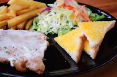 Izgara biftek, patates kızartması ve sebze.