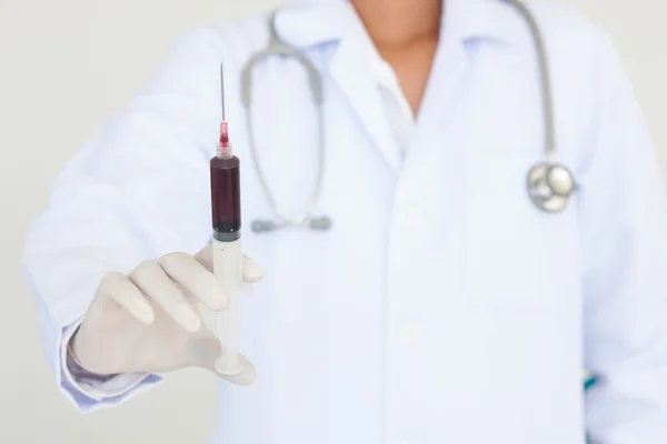 Segurando uma seringa com sangue — Fotografia de Stock
