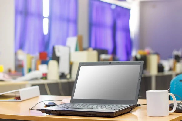 Ein Laptop-Computer auf einem hölzernen Schreibtisch mit einer heißen Kaffeetasse in o — Stockfoto