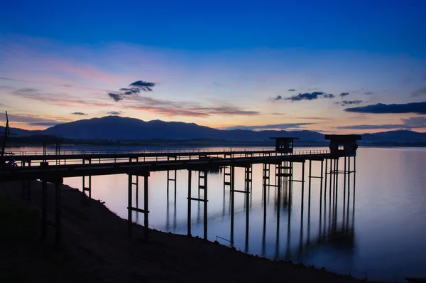 Old bridge at the lake with sunrise. — Stock Photo, Image