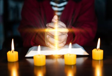 Hıristiyan dini için dua ederken ve ibadet ederken vücudunun arka planı bulanık, elleri kapalı bir İncil için dua eden sıradan bir adam. Hıristiyanlık geçmişi. özgürlük.