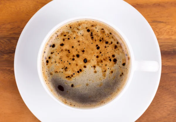 Vista superior de uma xícara de café preto em madeira — Fotografia de Stock