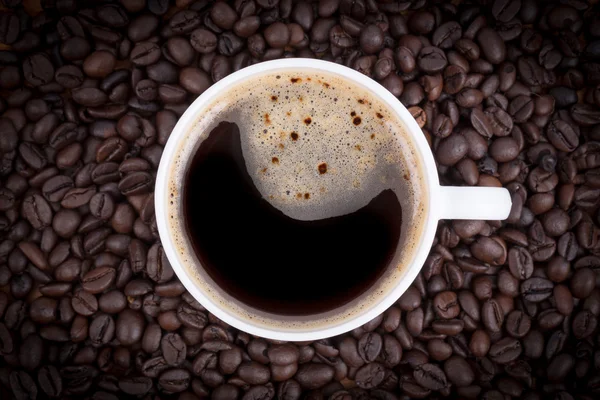 Pohled shora na šálek kávy na kávová zrna pozadí — Stock fotografie