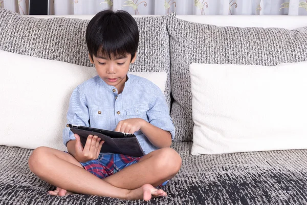 Мальчик играет с цифровым планшетом — стоковое фото