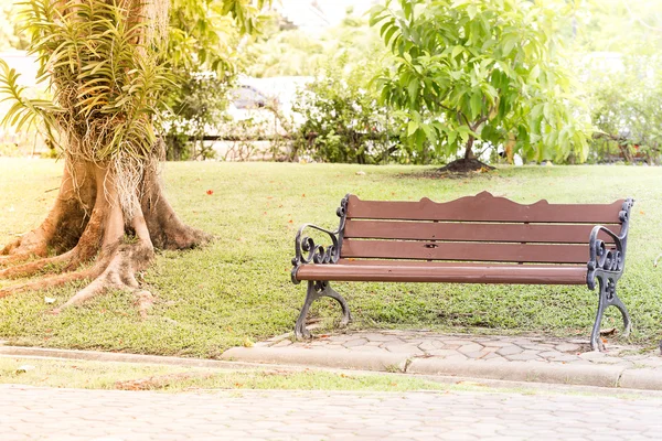 Een bankje in het steegje in het park op een zonnige dag — Stockfoto