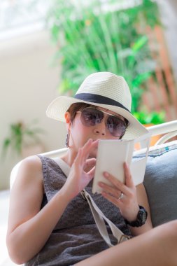 Güzel Asyalı kadın sandalyede oturan ve bana bir metin okuma