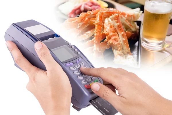 Hand Using Credit Card Machin with Food in Background For Your R