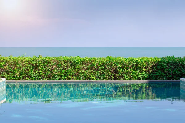 Piscina con el océano y la luz del sol de fondo — Foto de Stock