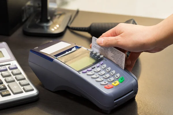 Mão deslizando cartão de crédito na loja — Fotografia de Stock