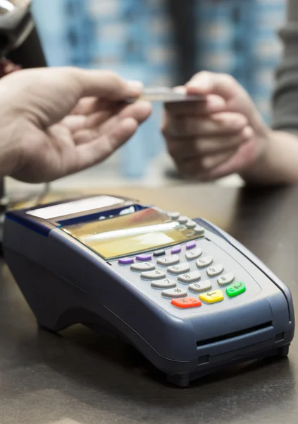 Máquina de tarjeta de crédito sobre la mesa con mujer entregando crédito — Foto de Stock