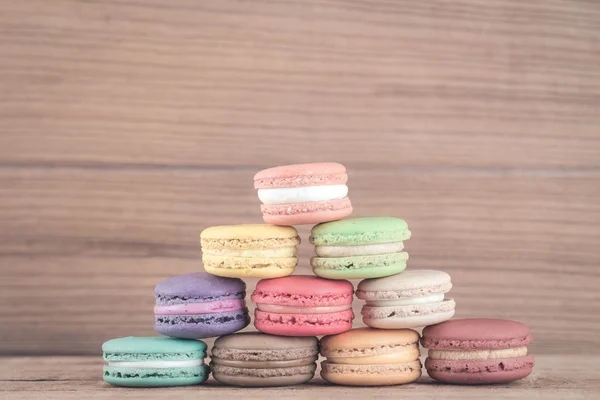 Imagem do foco da pilha de Macarons franceses coloridos no backgrou de madeira — Fotografia de Stock