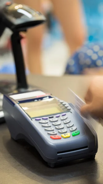 Movimiento de la mano que desliza la tarjeta de crédito en la tienda: enfoque selectivo Imágenes de stock libres de derechos