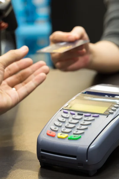 Credit Card Machine on the Table with Woman handing over credit