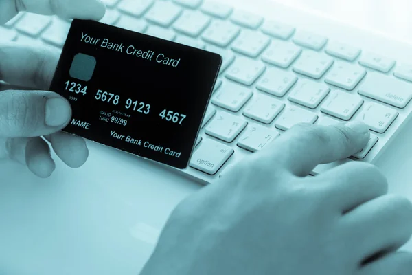 Ręka trzyma karty kredytowej i pisania. Zakupy on-line i — Zdjęcie stockowe