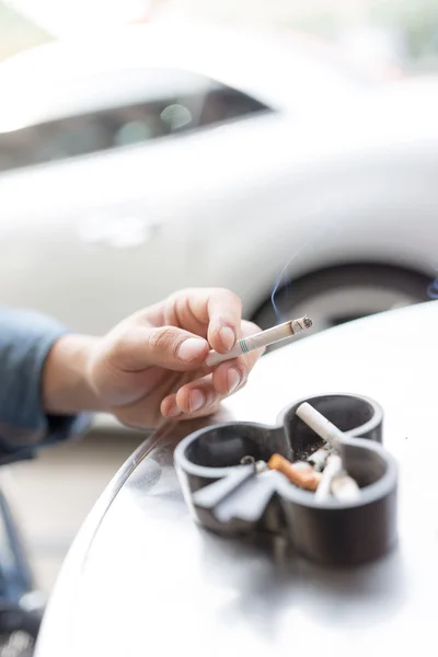 Mannen röker cigarett och använder ett askfat — Stockfoto