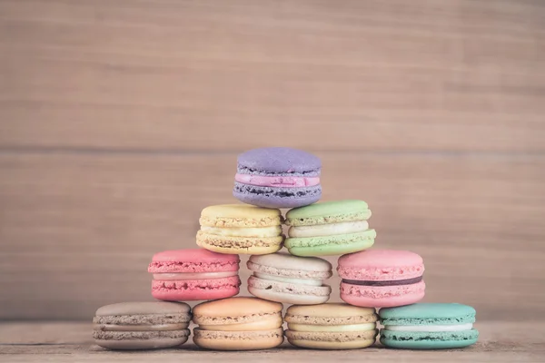 Imagem do foco da pilha de Macarons franceses coloridos no backgrou de madeira — Fotografia de Stock