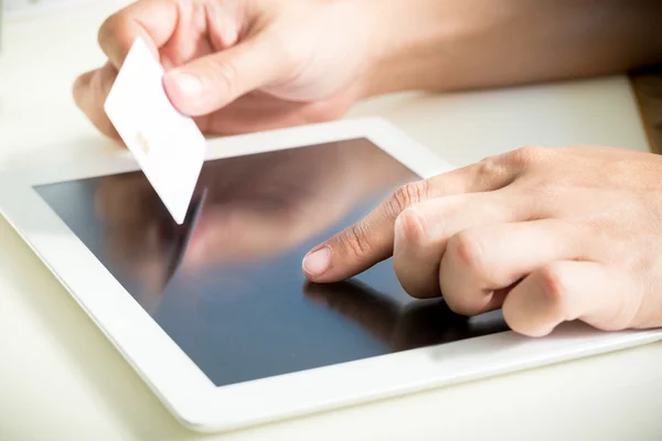 Mãos segurando um cartão de crédito e usando tablet pc para compras on-line — Fotografia de Stock