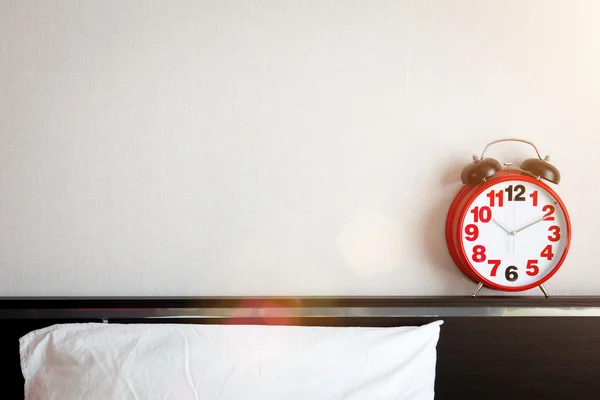 Relógio de alarme vermelho na cama com copyspace — Fotografia de Stock