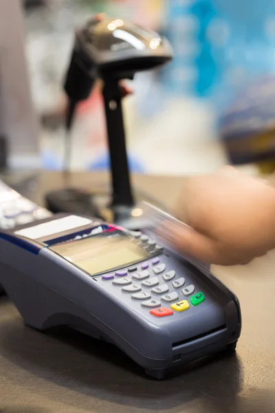 Mão deslizando cartão de crédito na loja — Fotografia de Stock