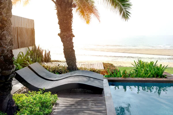 Кровать у бассейна на пляже с солнечной вспышкой Стоковая Картинка