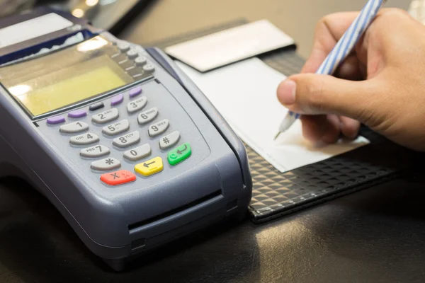 Kreditkartenautomat mit Unterschrift-Transaktion im Hintergrund lizenzfreie Stockbilder