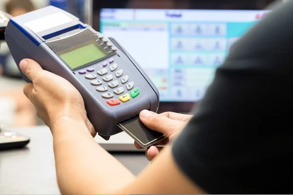 Ręka mężczyzny z machnięcia karty kredytowej za pośrednictwem terminali na sprzedaż w — Zdjęcie stockowe