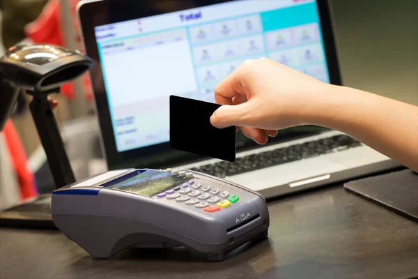 Mão com cartão de crédito deslize através do terminal para venda na loja — Fotografia de Stock