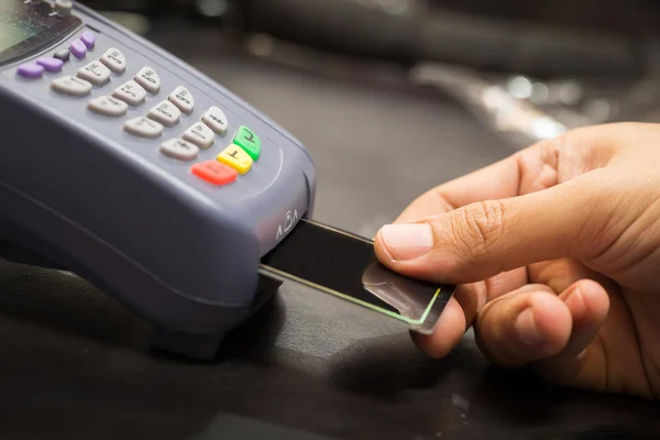 Primer plano de la mano con tarjeta de crédito pase a través de la terminal para Sal Fotos de stock