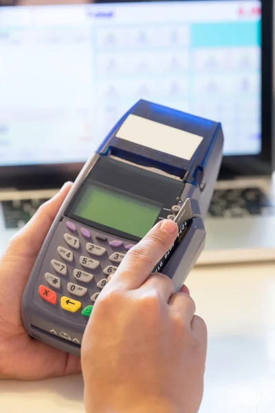 Mão com cartão de crédito deslize através do terminal para venda na loja — Fotografia de Stock