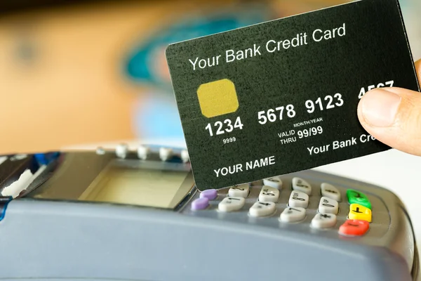 Χέρι που κρατά μια πιστωτική κάρτα με πιστωτική κάρτα μηχανή Εικόνα Αρχείου
