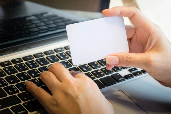 Ręka trzyma puste karty kredytowej na laptopa: Zakupy Online Con — Zdjęcie stockowe