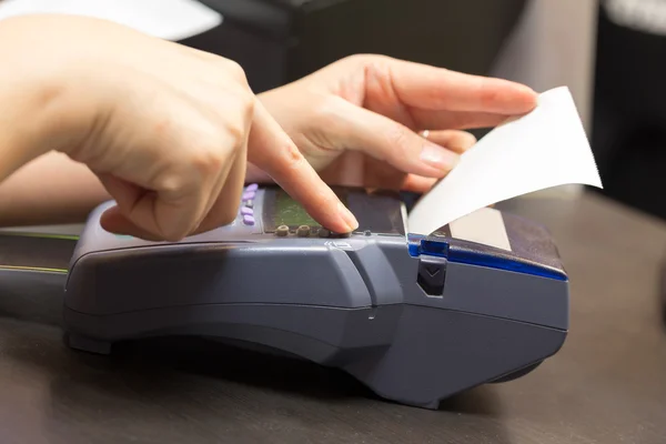 Hand mit Kreditkartenschwenk durch Terminal zum Verkauf im Geschäft — Stockfoto